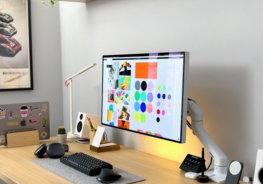 a computer monitor sitting on top of a wooden desk
